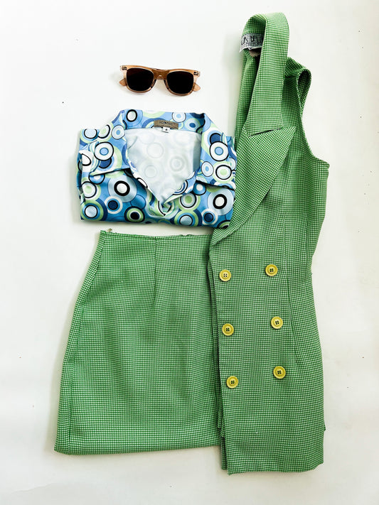 60s inspired outfit flat lay with a geometric top, and lime green suit set to match